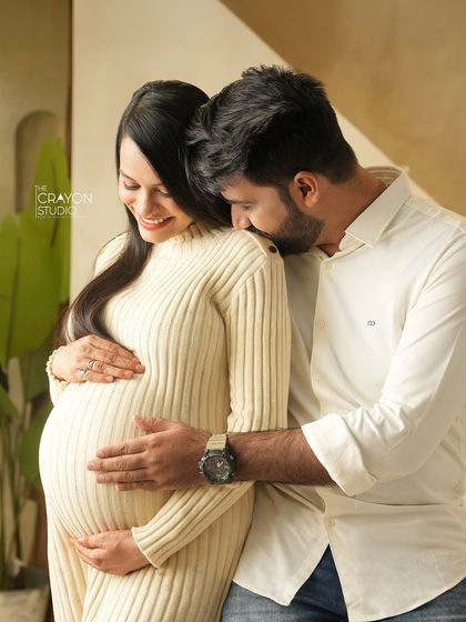 A gentle kiss on the shoulder. This intimate gesture, combined with the soft studio lighting, creates a romantic and heartfelt portrait.