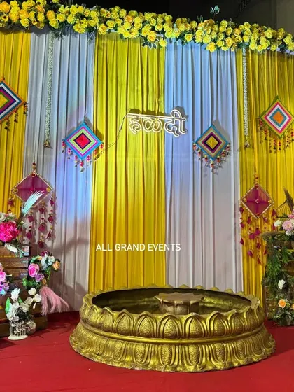 A perfect backdrop for a vibrant Haldi ceremony. We used bright yellow and white drapes, accented with traditional Rajasthani hangings and a 'हळदी' sign in Marathi script. The setup is completed with a large brass urli at the center, ready for the rituals.
