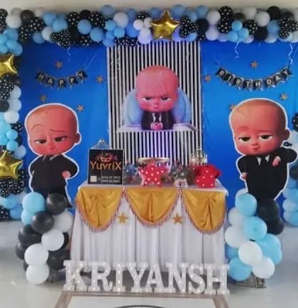 A Boss Baby decoration with a blue backdrop and black and white polka dot balloons. The setup features a central table and character props on balloon pillars.