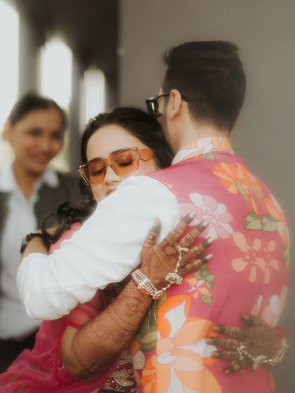 A warm embrace filled with emotion. This soft-focus shot captures the feeling of a heartfelt hug during the Haldi ceremony, a moment of pure connection amidst the celebrations.