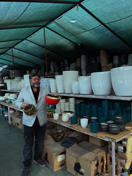 Another view of our extensive ceramic pot collection. You can see the different sizes and styles we keep, from large white planters to smaller, colorful ones.
