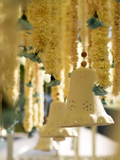 Hanging ceramic bells and floral strings were used to create a beautiful, textured ceiling installation.
