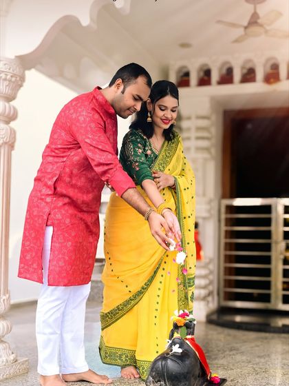 A beautiful moment of devotion during a traditional maternity shoot at a temple. The couple's vibrant ethnic wear adds a rich cultural element to their pregnancy photos.