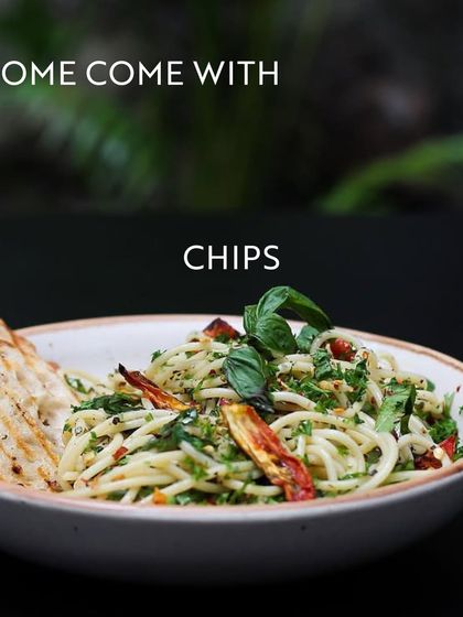 A delicious bowl of pasta with grilled bread, captioned 'Some come with chips'. This continues the visual story of how meetings here are more than just agendas; they come with great food.