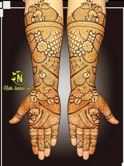 A heavy Indian bridal design with beautiful symmetry. The patterns include peacocks at the top of the arm and a mix of floral and geometric work all the way to the fingertips.