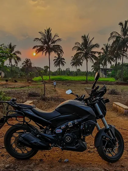 A black Dominar parked in a rural landscape at sunset. It's about finding beauty in the simple, quiet moments of a ride.