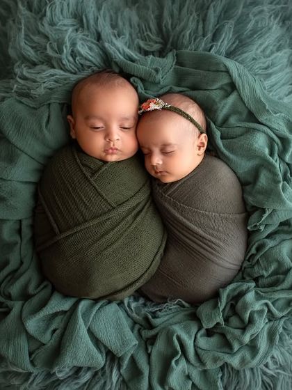 Two little bubs swaddled in shades of green, sleeping cheek to cheek. The bond between twins is just magical to witness and capture.