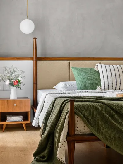 A bedroom should be a personal retreat. For the 'Poorna' primary room, the request was for a poster bed that didn't overwhelm the space. Our solution was this custom half-poster bed, which provides a sense of classic elegance. The textured grey wall and warm wood tones create a calm, cozy, and stylish sanctuary.