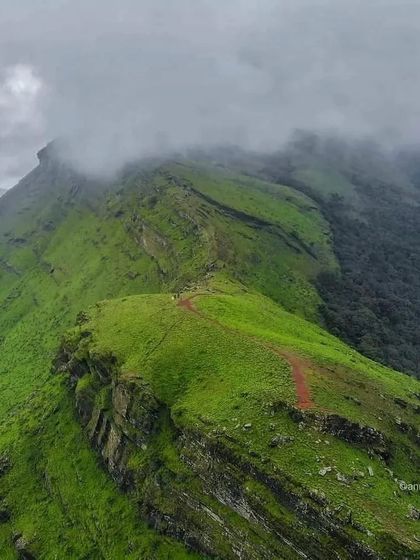 The famous winding path of the Mullayanagiri trek, with clouds covering the peaks.