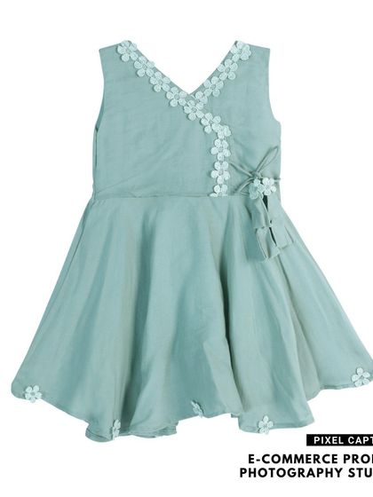 This angled shot of a baby dress shows the V-neck floral detail and the overall shape of the garment.