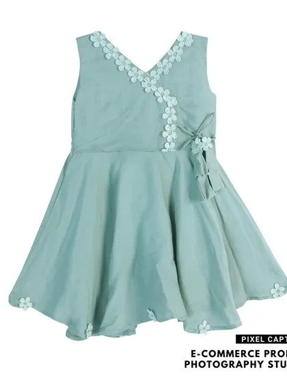 A beautiful flat lay of a light green, V-neck baby frock with floral details, ready for your online boutique.