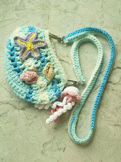 Here is the mini version of my popular Ocean Bag, perfect for a little one or for when you just need to carry the essentials. It has all the same handmade details, like the starfish and jellyfish charm, just in a smaller size.