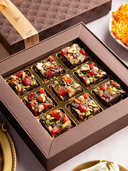 A box of rich, nutty date squares, a healthier yet indulgent option for festive gifting. Each square is packed with dates, nuts, and dried fruits, offering a burst of flavor and energy.