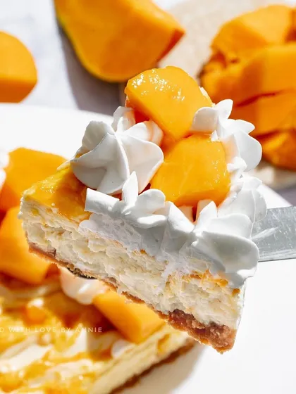 A perfect slice of my Baked Mango Cheesecake. The creamy texture, sweet mango flavor, and buttery crust make this a luxurious treat you won't forget.