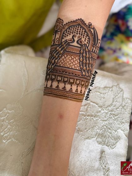 An intricate arm band design for a bride who preferred no human figures, featuring two peacocks in a royal archway.