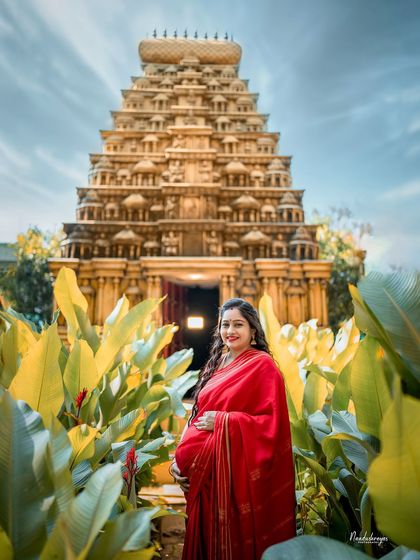 A solo maternity portrait in front of the temple gopuram, creating a powerful and serene image.