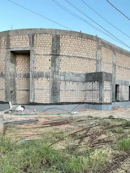 The exterior of the House of Galleries under construction, showing its solid, monolithic form built from local bela stone blocks.