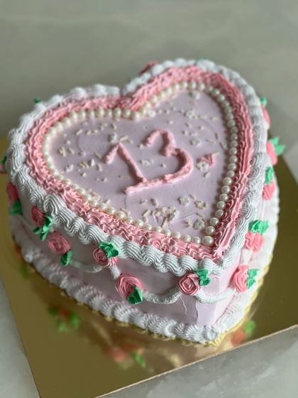 A vintage-style heart-shaped cake, perfect for a 13th birthday. The intricate piping and delicate rosebuds give it a classic, nostalgic feel that’s very on-trend.