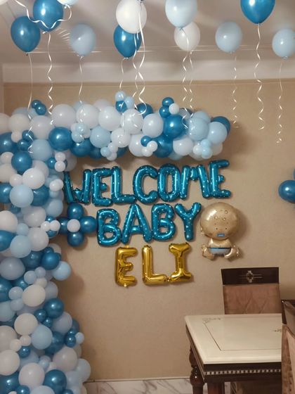 Here is a closer look at the personalized foil balloons used to welcome baby Eli. The combination of blue "Welcome Baby" letters and golden name balloons creates a beautiful focal point for the decoration.