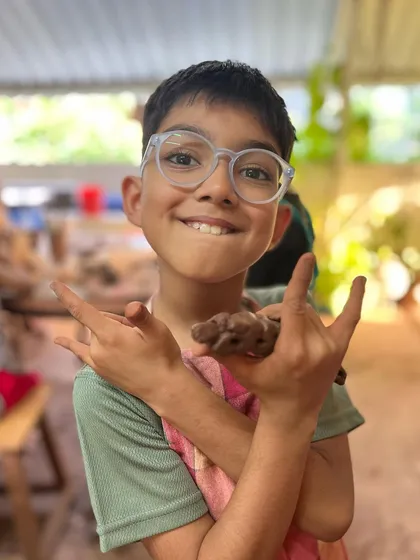 The excitement of a young creator. This boy is thrilled with the clay piece he sculpted during one of our basic workshops for families.