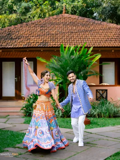 A joyful, candid shot of the couple dancing together in the gardens during their Mehendi party in Goa.