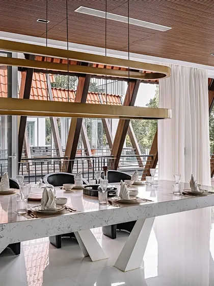 From this angle at Tellado Villas, you can see how the dining area overlooks the unique parabolic roof structure. The design intentionally blurs the lines between interior and exterior, making the architecture an integral part of the view.