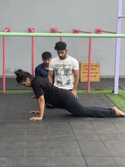 This is a duplicate of media ID 1, showing a coach correcting push-up form. This repetition emphasizes our core value of hands-on guidance and perfecting the fundamentals.