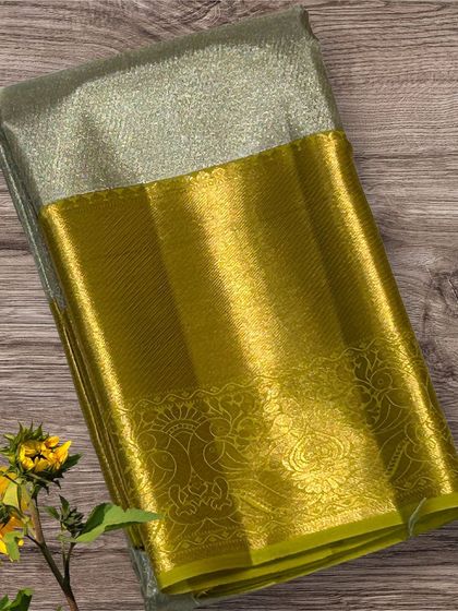A unique Kanchi silk saree with a silver tissue body and a lime-gold border.