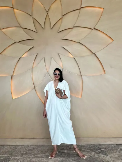 A full-length view of the white kaftan, showing its beautiful drape and movement.
