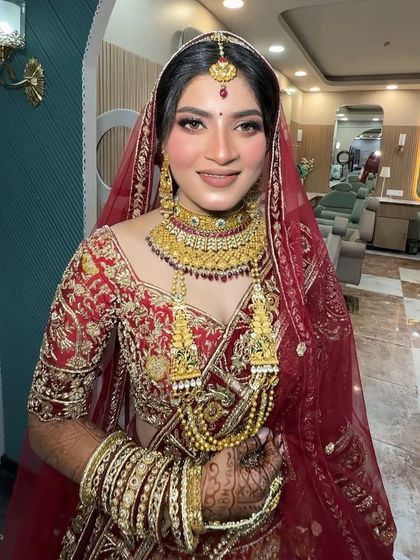 Another shot of this beautiful bride, showing her complete look. The traditional jewellery and red outfit are classic choices for any Indian wedding.