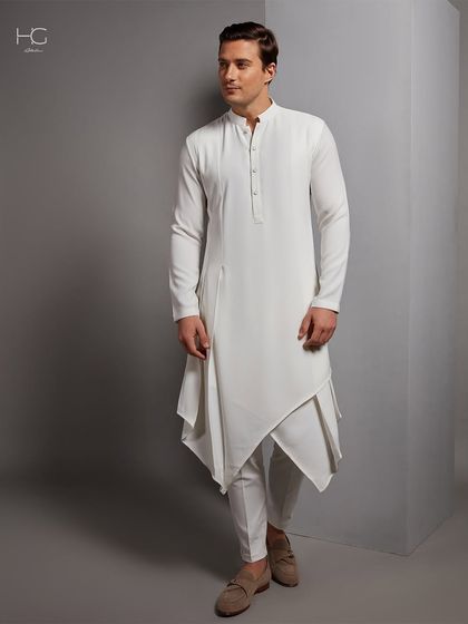A full view of the white asymmetrical kurta. It’s a statement piece that is both elegant and avant-garde, perfect for the fashion-forward groom.