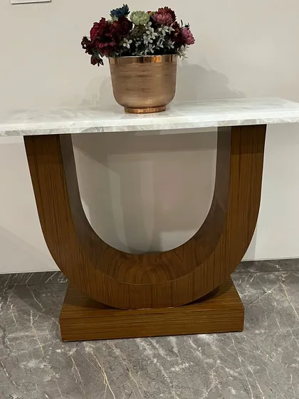 A custom-made console table with a U-shaped wooden base and a white marble top. This piece was designed to fit perfectly in a client's home.