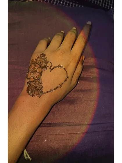 A creative and modern design featuring a heart shape outlined with beads and filled with small flowers on one side.