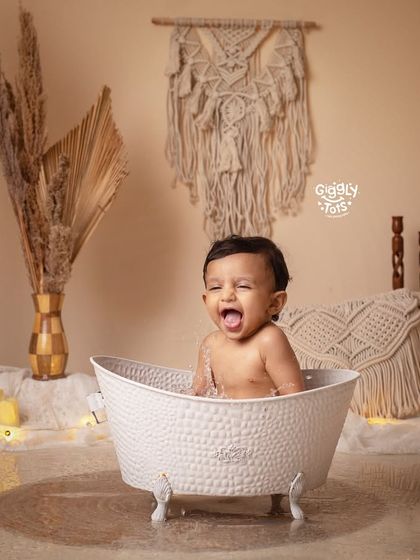 So much fun! A happy baby splashes and plays in a clawfoot tub, his laughter filling the studio.