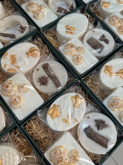 A vintage-themed birthday return favor box with white and gold honey almond and lavender soaps.