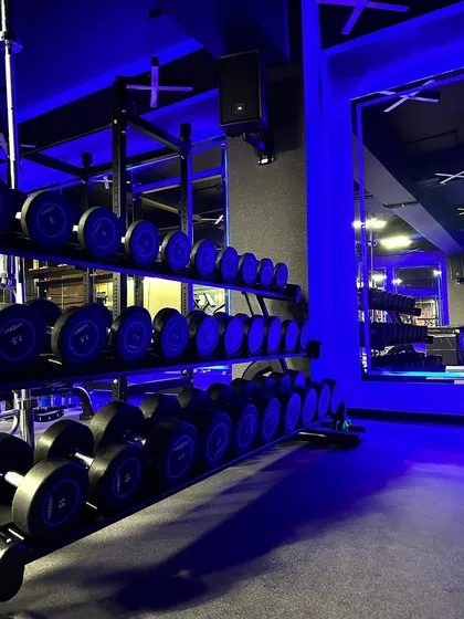 Our dumbbell rack is fully stocked with a wide range of weights to accommodate every fitness level. The clean, organized layout and moody lighting make it an inviting space to build strength.