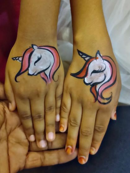 Two hands, two matching unicorn tattoos. A great idea for best friends at a party.