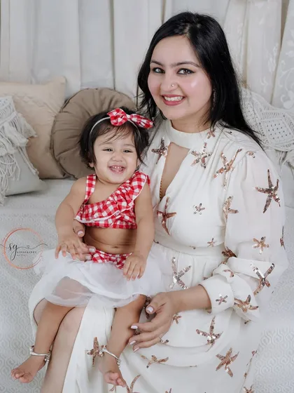 A beautiful mother-daughter portrait. The coordinating outfits and genuine smiles make this a heartwarming shot, capturing the special connection between a mother and her little girl.
