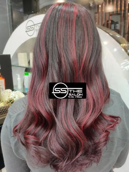 A beautiful example of a cherry red hair color. The soft waves and rich tones create a trendy and fashionable look that's full of life.