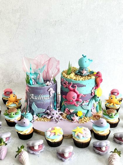 A double-cake dessert table for a shared "under the sea" birthday party. We created two unique cakes and a whole school of colourful cupcakes and chocolate-covered strawberries.