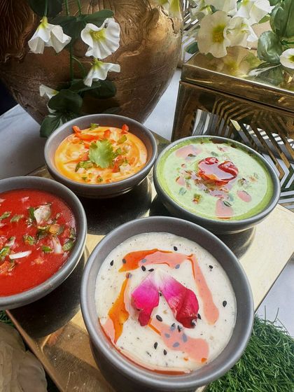 A selection of our vibrant and flavorful raitas and dips. We use fresh ingredients and beautiful garnishes like rose petals to make even the simplest accompaniments special.