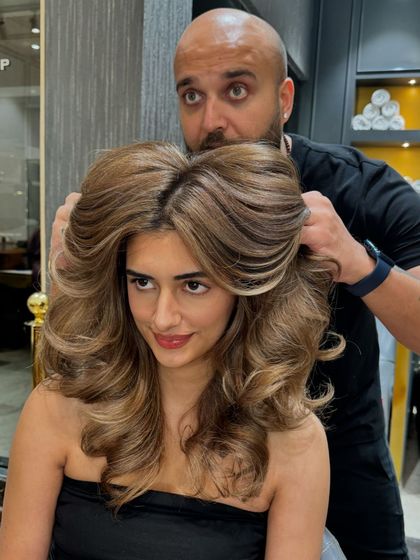The client showing off her new hair color. The voluminous styling and beautiful blonde tones create a glamorous effect.