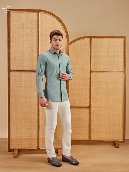 This mint green shirt with sleeve strap details is for the man who owns summer in style. It’s a fresh, contemporary piece that pairs perfectly with white trousers.