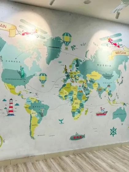 We brought a sense of adventure to this kids' room with a personalized world map wallpaper. The design is both educational and playful, featuring custom name banners for 'Hussain' and 'Naisam', making it a unique and engaging feature wall for young explorers.
