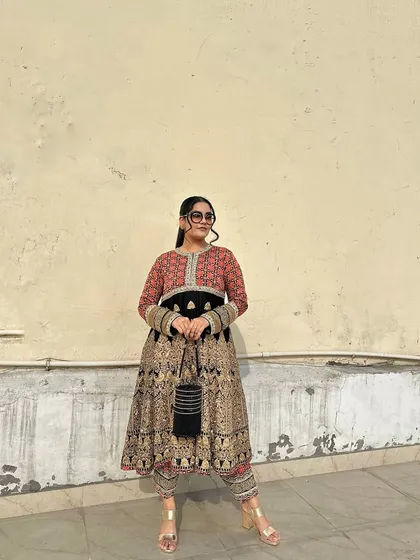 Another angle showcasing how the black potli is a versatile and elegant choice for any formal ethnic wear.