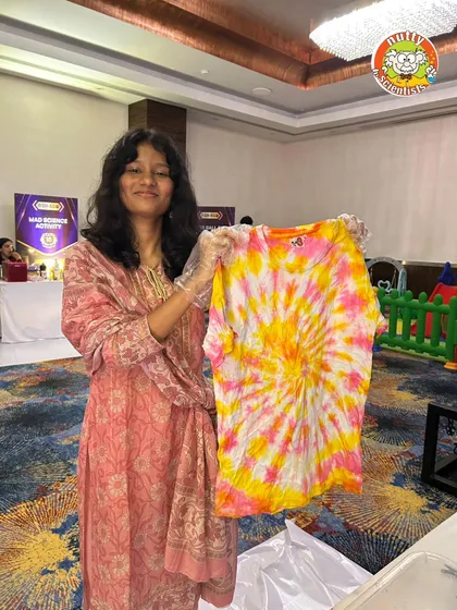 Our events aren't just about watching; they're about creating. Here, a participant proudly shows off the vibrant tie-dye t-shirt she made at one of our corporate event workshops. It's a fun, creative activity and a fantastic souvenir to take home.
