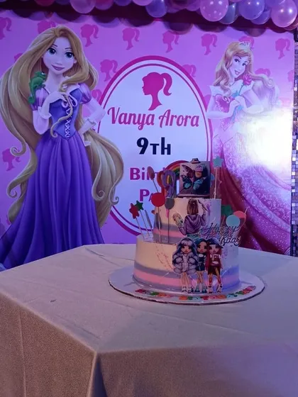 The beautifully decorated cake for the Barbie-themed party, placed in front of the custom backdrop.