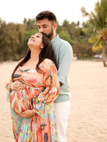 A beautiful portrait of the couple on the beach, with the mother-to-be looking up blissfully.