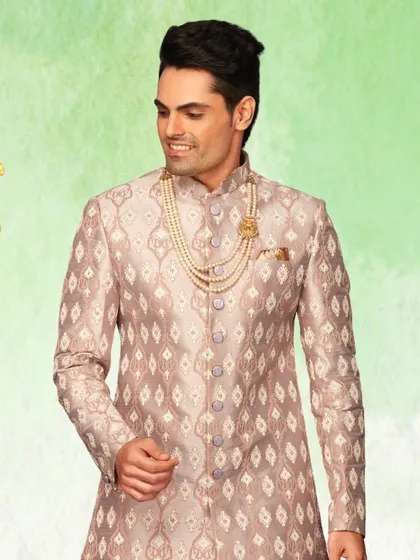A closer look at the mauve sherwani, showing the detailed pattern and the elegant accessory pairing. We help you style the complete look.
