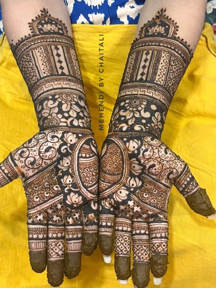 A traditional sider mehendi design that covers the full hands. It features a mix of floral, paisley, and geometric patterns, perfect for wedding guests who want an intricate look.